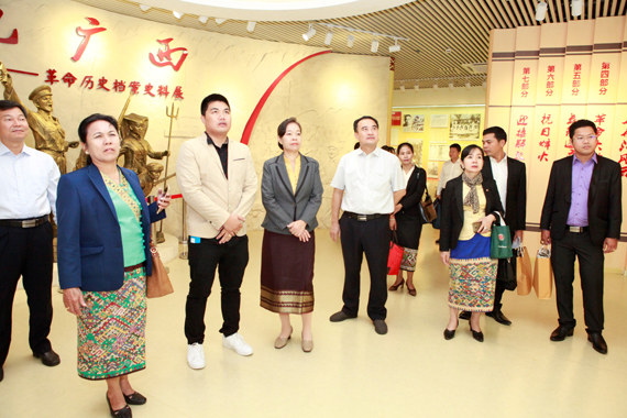 自治區檔案局館長黎富文（左五）同老撾國家檔案局局長通占·嬌森宏（左四）一起參觀《紅色廣西——革命歷史